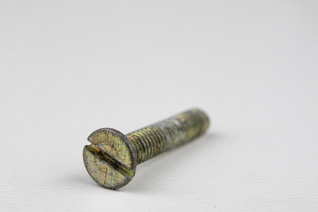 Screw head on a white table. Accessories for screw connections. Light background.