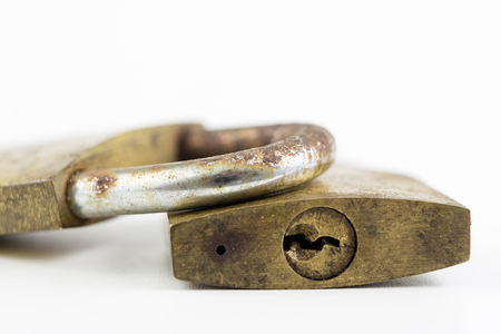 Brass padlock on a white table. Accessories for locking and securing against burglary. White...
