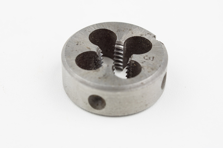 Device for making threads in a screw. Metalworking accessories. White background.