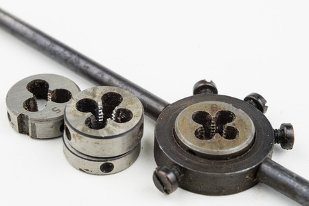 Device for making threads in a screw. Metalworking accessories. White background.