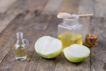 Onion juice and vegetables on a wooden table. Home-made syrup for the treatment of influenza. Dark background.の写真素材