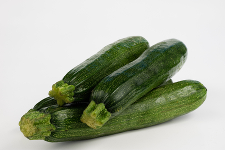 Zucchini on a white table. Tailor measure to measure the waist circumference during the diet. Light background.の写真素材
