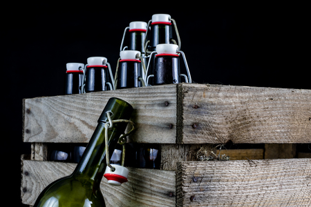 Old bottles in a wooden case. Drinks in old glass containers. Dark background.の写真素材