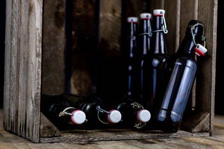 Old bottles in a wooden case. Drinks in old glass containers. Dark background.の写真素材