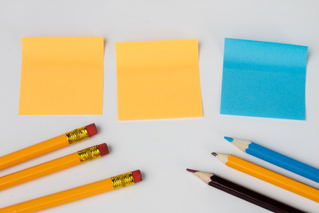 Pencil and sticky notes on a white table. Office accessories for saving notes. White background.の写真素材
