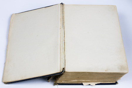 Old destroyed book on a white table. Old-style cover. White isolated background.