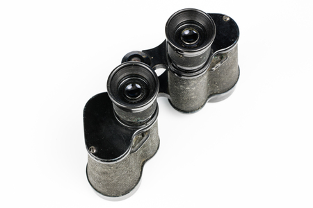 Old metal binoculars on a white table. Old military accessories for infantry. White background.の写真素材