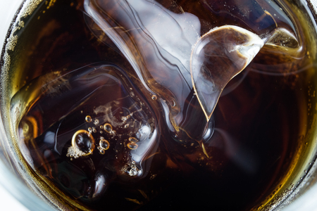 Cold drink with ice in a glass on a white table. A way to cool down on hot days. White background.の写真素材