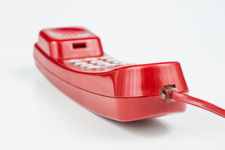 Old red phone with a handset. A telephone set from the nineties. White background.の写真素材