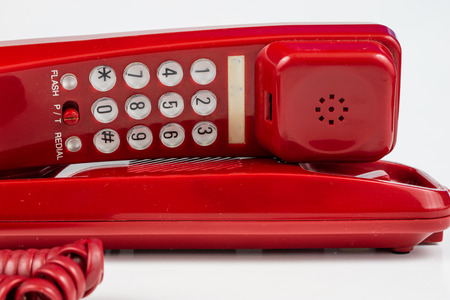 Old red phone with a handset. A telephone set from the nineties. White background.の写真素材