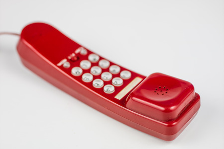 Old red phone with a handset. A telephone set from the nineties. White background.の写真素材