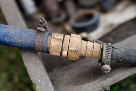 Connecting garden hose for watering. Old garden accessories. Season - summer.の写真素材