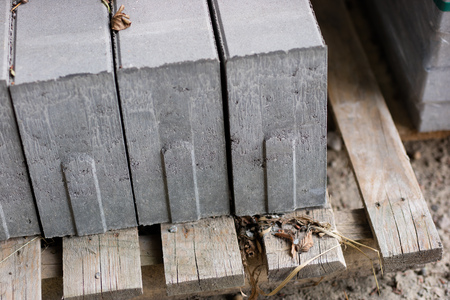 Road construction materials stacked on a pallet. Concrete curb for reinforcing the road shoulder....