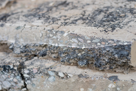 Cracked asphalt on the road for vehicles. Damaged road surface. Season of the summer.