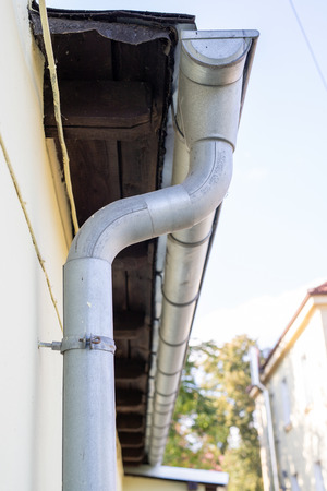 Gutter draining rainwater. The building is equipped with drainage of rainwater from the roof. Season...