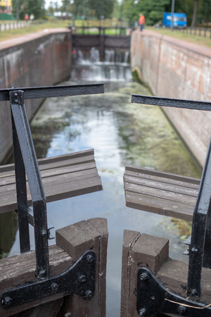 Old sluice on the channel in Central Europe. A wooden dam on the river. Season of the autumn.の写真素材