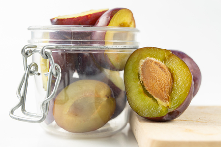 Fresh plums prepared for jam. Tasty fruits on a wooden board in the kitchen. White background.の写真素材