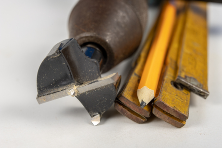 Measure and pencil on a white workshop table. Tools in a carpentry workshop. White background.