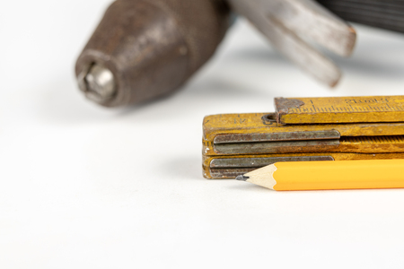 Measure and pencil on a white workshop table. Tools in a carpentry workshop. White background.の写真素材