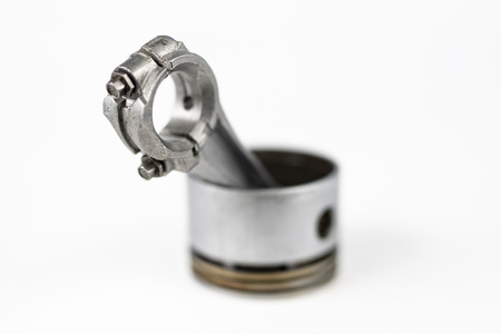 A small combustion engine piston on a white table. Spare parts for mechanics. White background.の写真素材