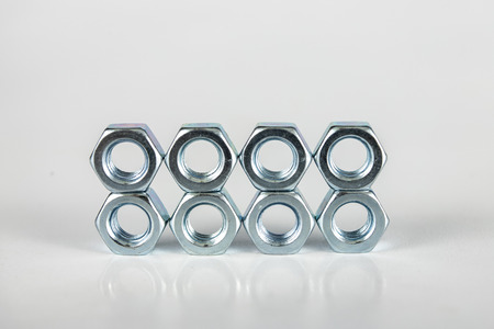 Chrome caps on a white table. Accessories for mounting steel structures on a workshop table. White...