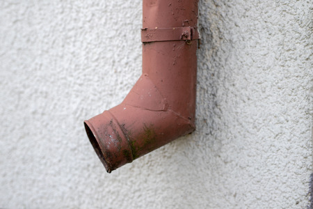 Gutter draining rainwater. The building is equipped with drainage of rainwater from the roof. Season of the summer.の写真素材