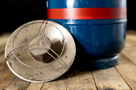 An old gas burner for preparing dishes. Tourist accessories on an old wooden table. Dark background.の写真素材