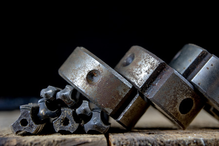 Metalwork tools on the workshop table. Threading dies and taps in an old dusty workshop. Black...
