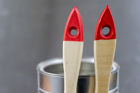 A paint brush and a can of paint on a workshop table. Painting accessories for construction workers. Light background.の写真素材