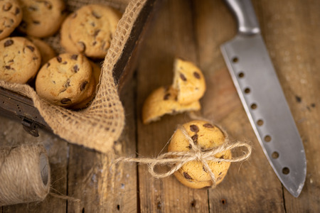 Cookies tied with a gray jute string into a bow. Cookies of sweets on a wooden kitchen table. Black...