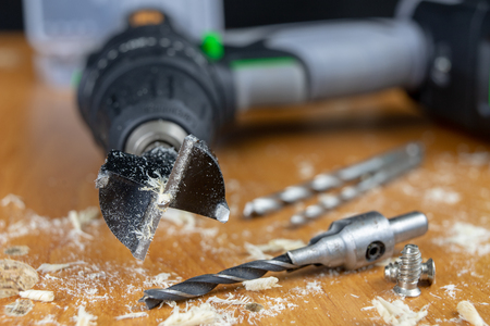 Installation of chipboard furniture in a carpentry workshop. Accessories and tools for carpenters. Dark background.の写真素材