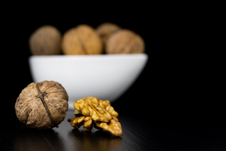 Tasty walnuts on a black kitchen table. Ingredients to prepare cista in home cooking. Black...