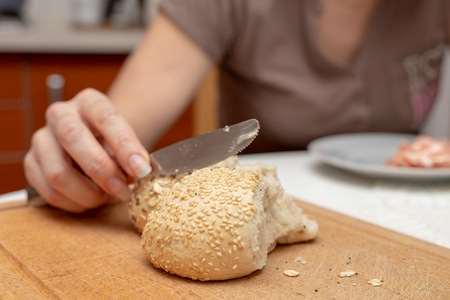 Tasty wheat roll on the kitchen table. Preparing dinner with fresh bread and butter. Autumn background.の写真素材