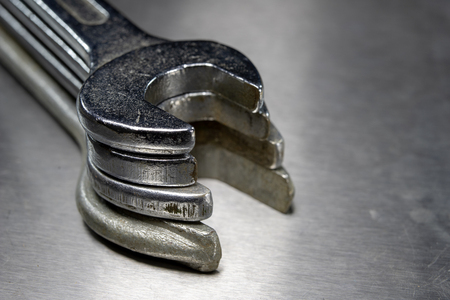 Wrench and nuts on a metal table in a workshop. Accessories for mechaics for minor mechanical repairs. Light background.の写真素材