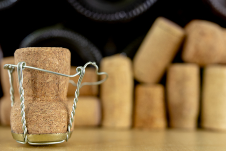 Corks from champagne on a wooden table. Wire protections and plugs after New Year's Eve. Light background.の写真素材