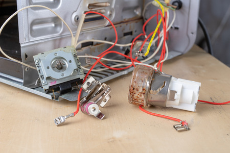 Spare parts for the repair of a household oven. A split stove for baking dishes. Light background.