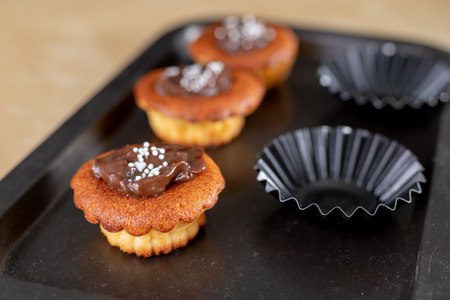 Tasty cupcakes decorated with chocolate. Dessert on a wooden table in the kitchen. Light background.の写真素材