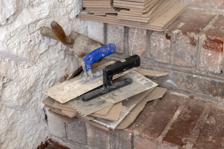 Laying tiles on the stairs in the basement. Prepared tiles and tools in the utility room. Light background.の写真素材