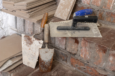 Laying tiles on the stairs in the basement. Prepared tiles and tools in the utility room. Light background.の写真素材