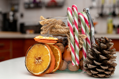 Dried oranges and nuts on a white kitchen table. Accessories for decorating in a home farm. Light background.の写真素材