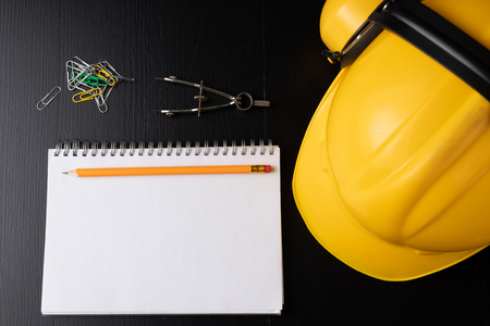 Engineer's desk prepared for work. Accessories prepared for a builder on a black table. Dark background.の写真素材