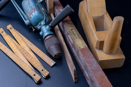 Tools for a carpenter on a workshop table. Accessories for a production worker. Dark background.