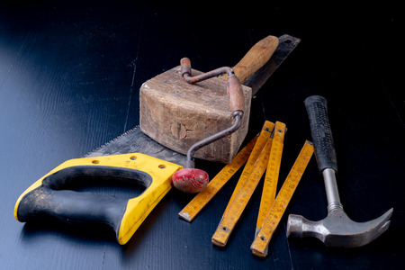 Tools for a carpenter on a workshop table. Accessories for a production worker. Dark background.の写真素材