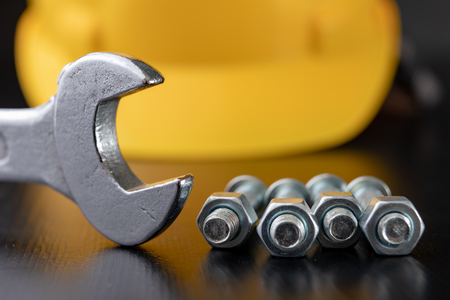 Screws, nuts and keys on a workshop table. Tools and accessories for mechanics. Black background.の写真素材