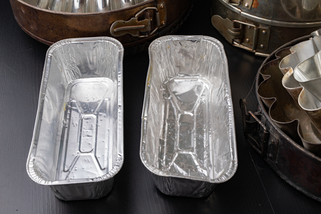 Molds for baking cakes in the home kitchen. Old dusty kitchen accessories. Dark background.の写真素材