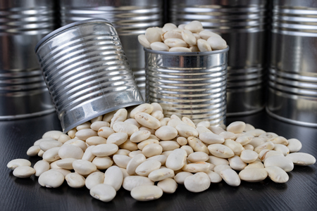 Tasty bean in a metal can on a wooden table. Products for preparing meals. Dark background.の写真素材