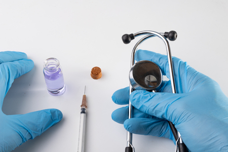 A small syringe, medicine and doctor's hands in gloves. Utensils necessary for treatment at the clinic. Light background.の写真素材