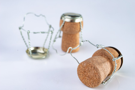 Champagne cork and metal basket on the table. Special closure from sparkling wine. Light background.