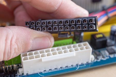 The motherboard and computer components. Computer accessories on a workshop table. Dark background.