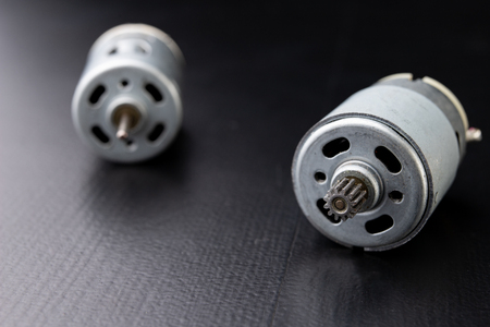 Small electric engine on a wooden dark table. Electric drive for small home appliances. Dark background.の写真素材